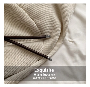 Close-up of premium silver metallic hardware and brown leather drawstring on a beige bag