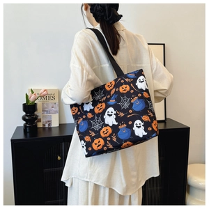 Halloween tote bag with pumpkin and ghost prints worn by a model in a cozy home setting