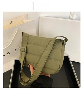 Detailed view of green quilted nylon crossbody bag with wide shoulder strap