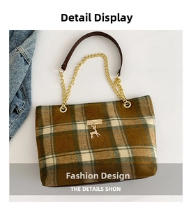 Detail of plaid tote bag with golden chain strap and a metallic deer charm accent