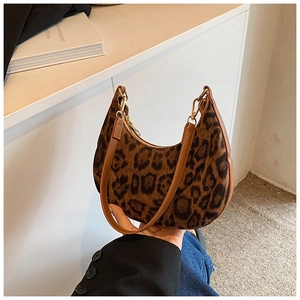 Detail of leopard print crescent bag featuring premium fabric texture and leather trim