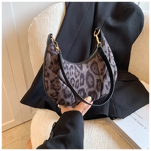 Macro shot of faux fur leopard print texture and black leather strap with gold hardware