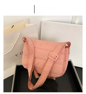 Close-up of pink quilted crossbody bag showing soft nylon fabric and adjustable strap