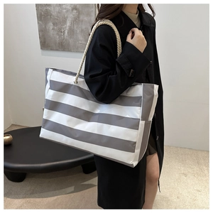 Detail of grey and white striped canvas tote bag with thick nautical rope handles