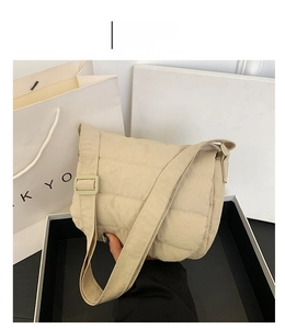 Detail of khaki quilted crossbody bag with diamond stitching and adjustable shoulder strap