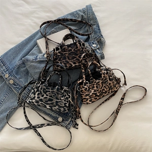 Chic leopard print mini tote bags in three colors on denim background with long straps