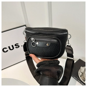 Detail of black lychee grain leather crossbody bag with silver zippers and metal rivets