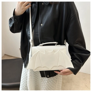 Détail d'un sac bandoulière blanc avec ailes de chauve-souris sur veste en cuir
