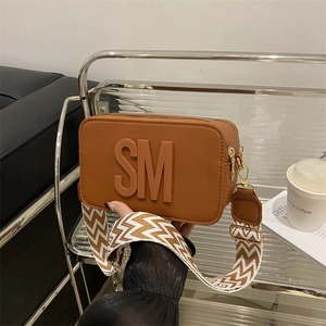 Brown camera bag with embossed logo and geometric pattern wide strap for women