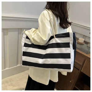 Close-up of woman wearing a black and white striped tote bag with cotton rope handles