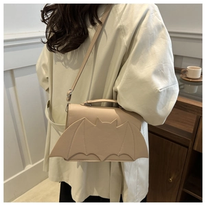 Détail du sac à bandoulière beige créatif en forme de chauve-souris avec coutures décoratives