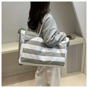 Detailed side view of a large striped canvas tote bag with cotton rope handles
