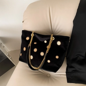 Elegant black velvet tote bag with gold floral accents and chunky chain strap detail