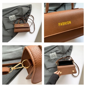 Close-up of brown litchi pattern leather bag with gold hardware and fashion text detail