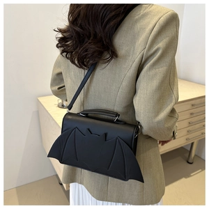 Détail du sac à main noir mat créatif en forme de chauve-souris avec design d'ailes et sangle