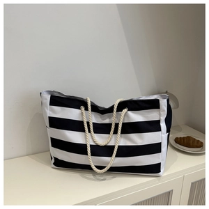 Detail of striped canvas tote bag with thick rope handles and functional side pocket