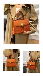 Detail of caramel brown croc-embossed small square bag with irregular gold metal buckle