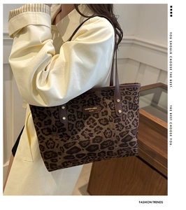 Détail du sac cabas léopard avec plaque de marque et accents de rivets dorés