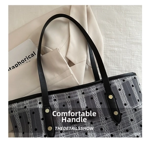 Detail of checkered tote bag with black mesh polka dots and leather handles