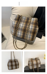 Detail of grey plaid wool tote bag with golden chain strap and textured fabric