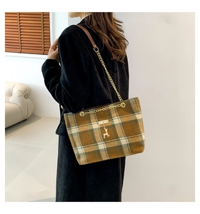 Detail of wool-like plaid tote bag featuring golden chain strap and deer charm