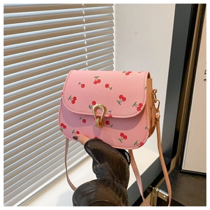 Détail du sac à bandoulière rose avec imprimé cerise et fermoir en métal doré