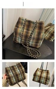 Detail view of green plaid wool bucket bag featuring golden chain strap and soft texture