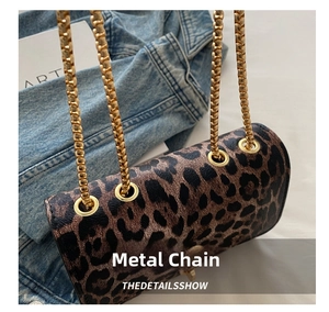Detailed view of leopard print shoulder bag with gold chain and polished eyelets