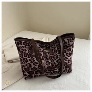 Close-up of leopard print tote bag with premium leather handles and brand logo tag