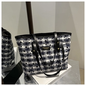 Close-up of checkered tote bag with blue white patterns and leather logo patch detail