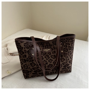Detailed view of the leopard print tote bag with leather straps and metal rivets