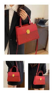 Detail of red crocodile texture handbag featuring a unique gold lava metal buckle