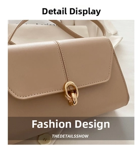Close-up of golden interlocking rings buckle on beige leather underarm bag