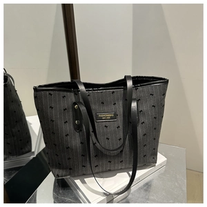 Detail of grey striped tote bag with bow embroidery and leather logo patch