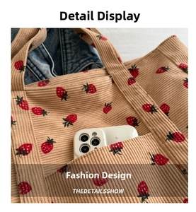 Detail of corduroy strawberry tote bag featuring a functional front pocket for a smartphone