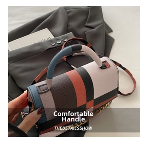 Detail of the plaid crossbody bag with leather top handle and gold chain strap