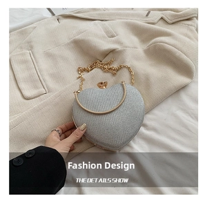 Detailed view of heart-shaped clutch with silver sequins and gold chain strap detail