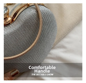 Close-up of glitter silver clutch bag with gold round metal handle and large crystal clasp