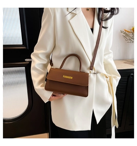 Close-up of brown litchi pattern leather crossbody bag with fashion lettering