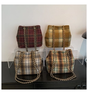 Close-up of vintage plaid tote bags in four autumn colors with metal chain straps