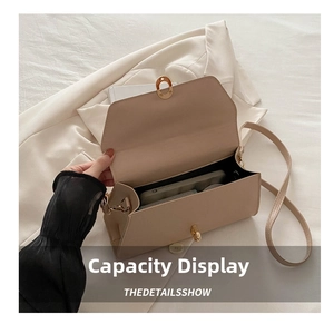 Detail view of beige leather underarm bag showing interior capacity and gold turn-lock clasp