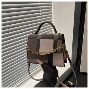 Detail of vintage plaid handbag featuring retro check pattern and gold chain strap