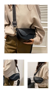 Detail of black saddle bag with matte leather finish and striped webbing strap