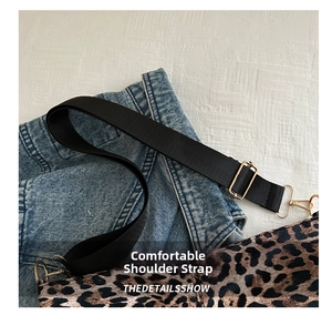 Detailed shot of leopard print tote bag with black strap and gold metal buckles