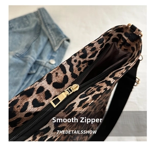 Close-up of leopard print tote bag with smooth golden metal zipper and black strap