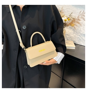 Close-up of beige litchi grain tote bag with FASHION logo and golden hardware