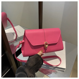 Close-up of rose pink PU leather handbag with golden double ring metal buckle and flap