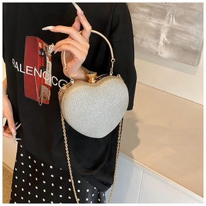 Macro shot of silver sequined heart evening bag with gold hardware and gemstone clasp