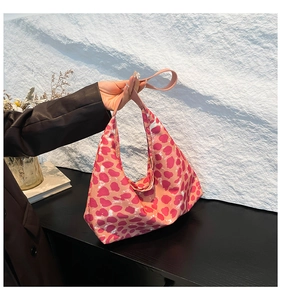 Detail of pink leopard print hobo bag showing soft canvas fabric and red spot pattern