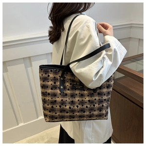 Close-up of checkered heart print tote bag with long leather handles and logo plate